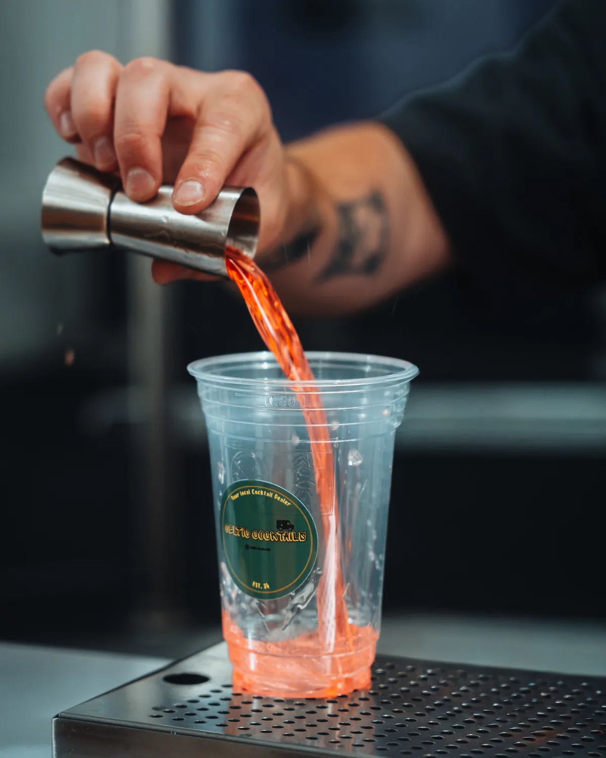 Serving a cocktail into a branded cup
